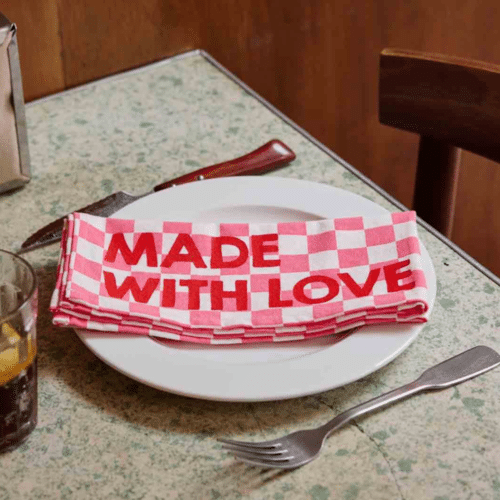 Set de 2 serviettes de table en coton, motif damier rose, message “Made with Love” en situation sur une table dressée