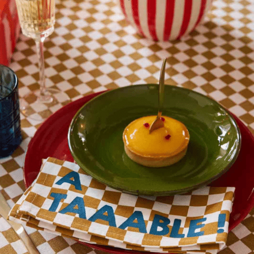 Photo de mise en situation d'une serviette en coton motif damier "A table" coloris caramel sur une table dressée