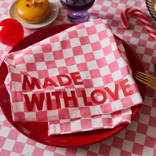 Set de 2 serviettes de table en coton, motif damier rose, message “Made with Love” en situation sur une table dressée