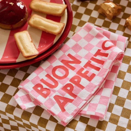 Set de 2 serviettes de table en coton, motif damier rose, message “Buon Appetito” en situation sur une table dressée