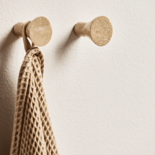 photo de mise en situation du Crochet bouton en travertin "Lakolk" - Nordal accroché au mur avec un torchon accroché