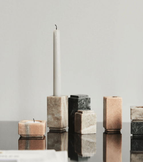 photo d'illustration présentant des bougeoirs en marbre disposés sur une table avec des bougies