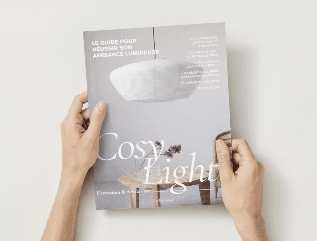 Cosy Light guide gratuit à télécharger pour réussir son ambiance lumineuse édité par Twicy Store tenu entre les mains d'une personne