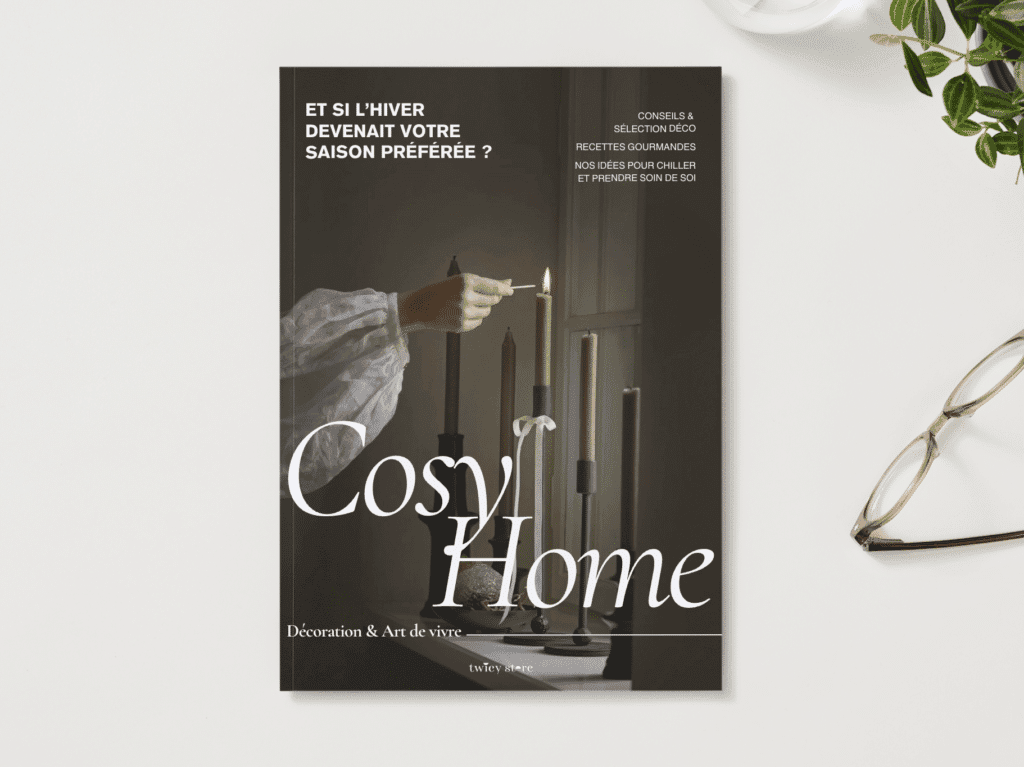 Couverture du guide "Cosy Home" édité par Twicy Store déposé sur un bureau avec des plantes vertes et une paire de lunettes