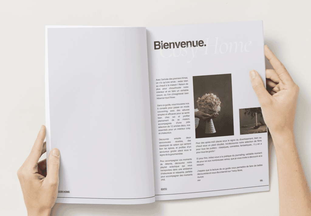 Guide "Cosy Home" tenu entre les mains d'une lectrice au dessus d'un bureau
