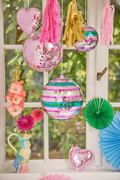 Photo de boules à facettes colorées suspendues devant une fenêtre