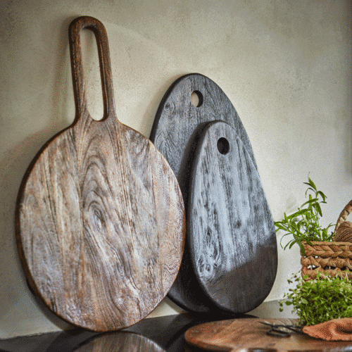 Planche à découper ovale en bois noir "Portland" - Twicy Store posée le long d'un mur de cuisine