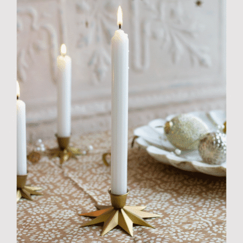 Grand bougeoir Etoile en laiton doré - Twicy Store disposée sur une table nappée devant un plateau décoratif