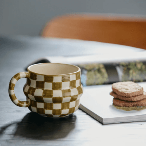 Tasse "Ysia" en grès motif damier vert - Twicy Store présenté sur une table à côté de biscuits