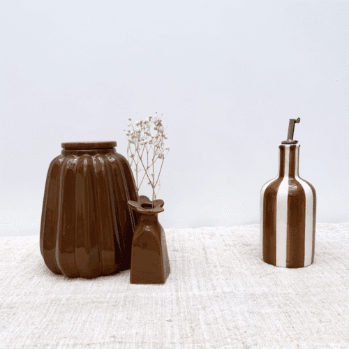 Huilier en faïence à rayures marron - Twicy Store présenté sur un plan de travail accompagné de deux vases marrons