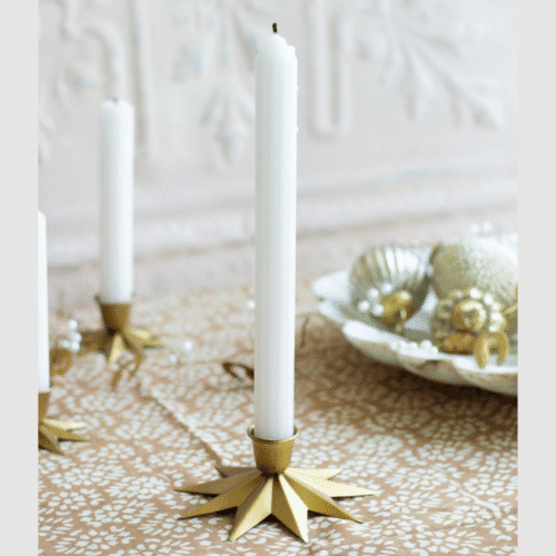 Grand bougeoir Etoile en laiton doré - Twicy Store disposée sur une table nappée devant un plateau décoratif