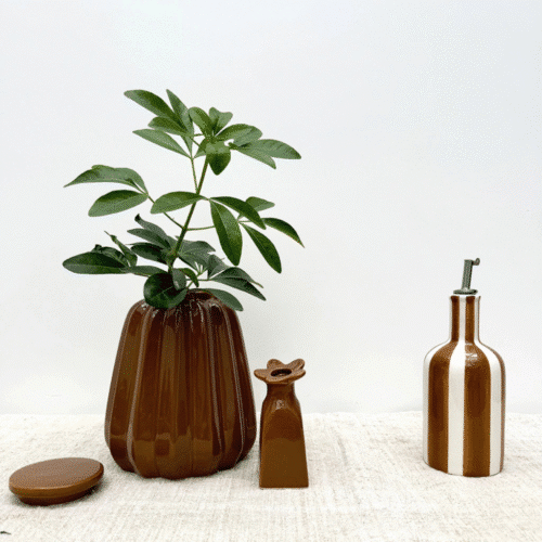 Huilier en faïence à rayures marron - Twicy Store présenté sur un plan de travail accompagné de deux vases marrons
