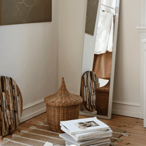 Panier en rotin avec couvercle "Pallas" - Twicy Store au sol sur un tapis dans une chambre devant un miroir