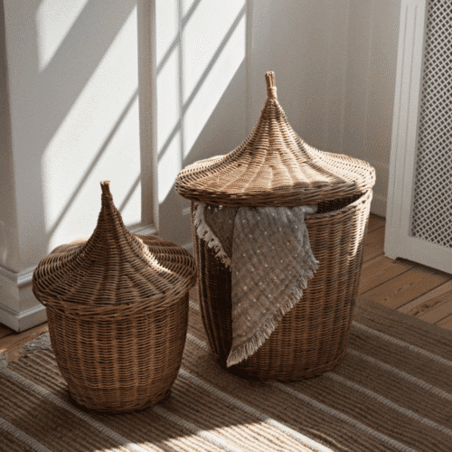Panier en rotin avec couvercle "Pallas" - Twicy Store au sol sur un tapis dans une chambre rempli de linge