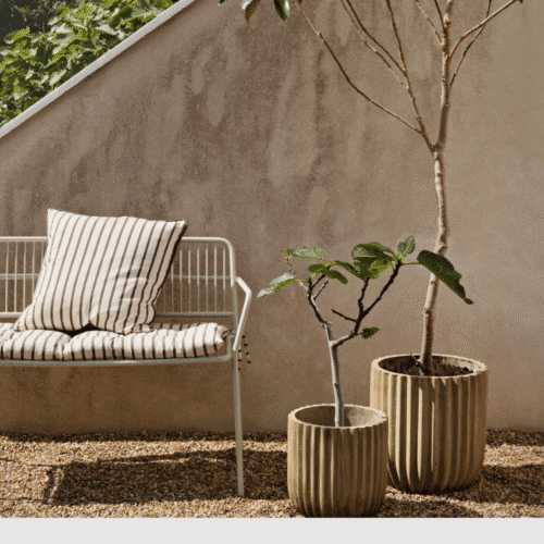 Housse de coussin en coton à rayures brun “Franca” - Twicy Store sur un banc en métal à l'extérieur